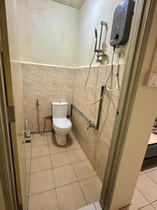 a bathroom with a toilet and a phone on the wall at Kanso Hill Guesthouse in Ranau +13 photos