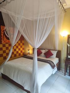 una camera da letto con un letto a baldacchino di Dalum Homestay ad Amed