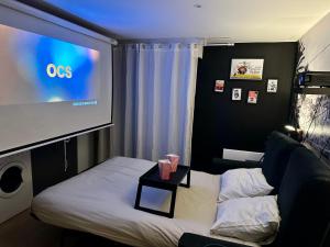 a room with a bed and a large tv at THEM'APPARTS Bordeaux Chartrons in Bordeaux