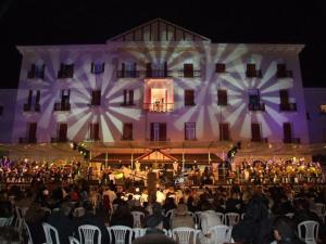 a crowd of people sitting in chairs in front of a building at Hotel Salvador in Poços de Caldas