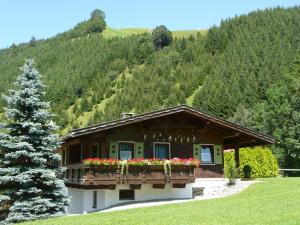 a house with a balcony with flowers on it at Chalet Tannheimer Tal in Zöblen