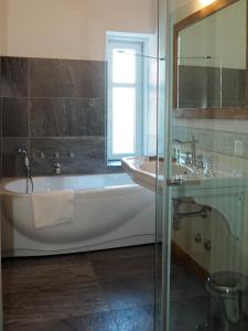 a bathroom with a tub and a sink at Maloja Palace Residence Engadin-St Moritz CO2-Neutral in Maloja
