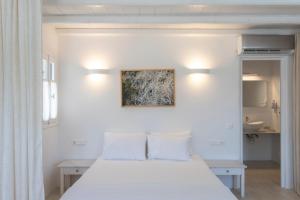 a bedroom with a white bed with two pillows at K Homes-Family Stone Suite in Tinos Town