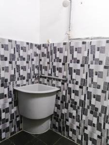 a bathroom with a tub and a tiled wall at SK Sweet Homestay SP Kedah in Sungai Petani