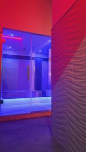 a room with red and blue lights and a wall at Hotel Butterfly Wellness & Spa in Rimini