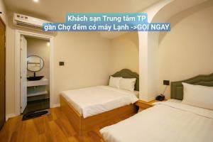 a bedroom with two beds and a mirror at HOTEL Minh Châu - KS Gần Ngay Chợ Đà Lạt - Có Điều Hòa in Da Lat