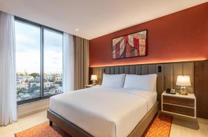 安曼Doubletree By Hilton Amman Hotel & Residences的一间带大床和大窗户的卧室