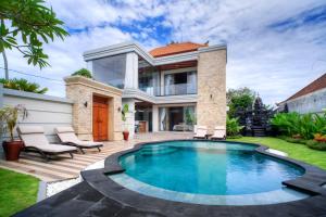 a swimming pool in front of a house at Jero Delod Guesthouse in Tabanan