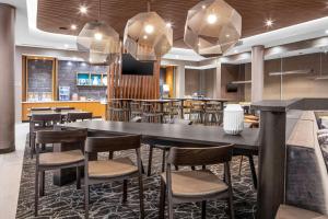 a restaurant with a large black table and chairs at SpringHill Suites Winchester in Winchester