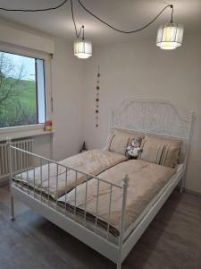 un letto bianco in una camera da letto con due luci di Zimmer mit Herz a Schwyz (Svitto)