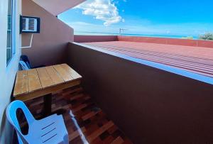 a balcony with a table and a bench on a building at RedDoorz @ 4ks Pension House Bogo City Cebu in Banban