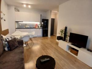 a living room with a couch and a table and a kitchen at DĘBOWA KUTNO in Kutno