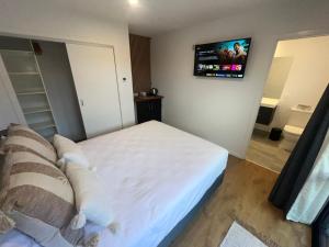 una camera da letto con un letto e una televisione a parete di Studio in Glenorchy a Glenorchy
