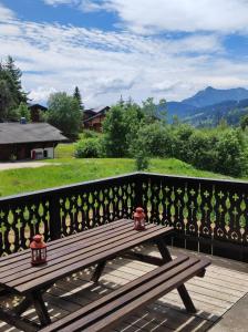 a wooden bench sitting on top of a fence at Le Chalet de Nabor in Les Gets