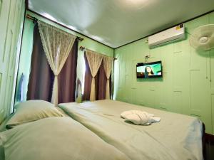 a bedroom with a bed with a tv on the wall at Boat and House Resort Khao Kho in Khao Kho +78 photos