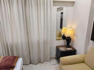 At TūbīStudio Apartments hygiene & Comfortable的客厅配有沙发和带台灯的桌子