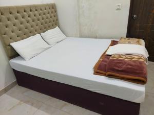 At TūbīStudio Apartments hygiene & Comfortable的一张带白色床单的床,一张毯子