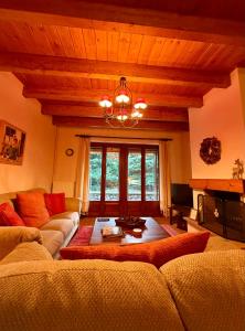 エプタロフォスにあるAnemoria Chalets-Castalia Chaletのソファとシャンデリアのあるリビングルーム
