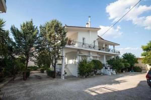 a white house with a balcony and trees at Nafplio Private Studio 2 in Nafplio