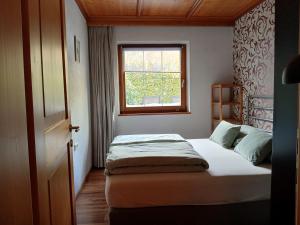 una piccola camera da letto con un letto e una finestra di Basecamp-Ried a Ried im Oberinntal