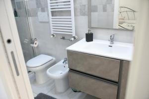 a bathroom with a sink and a toilet and a mirror at Rome Sea in Lido di Ostia +66 photos