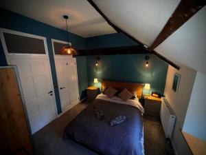 ein Schlafzimmer mit einem großen Bett mit blauen Wänden in der Unterkunft 2 Bedroom Cottage in Bower Hinton - The Music Barn! in Martock
