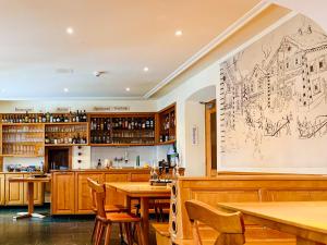 a restaurant with wooden tables and a drawing on the wall at Golf Hotel Des Alpes in Samedan