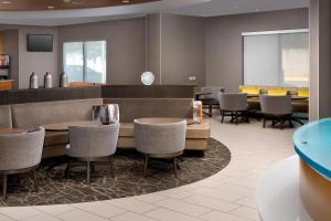 a restaurant with chairs and a table and a bar at SpringHill Suites Alexandria in Alexandria