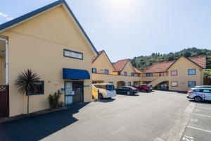 ファンガレイにあるBella Vista Motel Whangareiの駐車場車の並ぶ建物