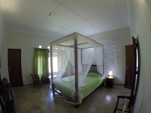 a bedroom with a green bed with a canopy at GalleRetreat in Galle