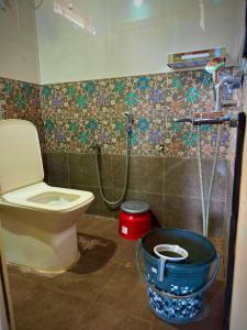 a bathroom with a toilet and a shower at MangoHut Farmhouse Pool Villa in Hyderabad +32 photos
