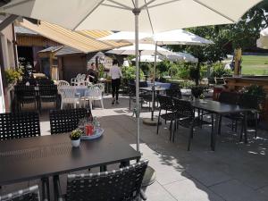 eine Außenterrasse mit Tischen, Stühlen und Sonnenschirmen in der Unterkunft Gasthof zum Schweizerhaus in Ricken