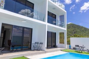 una casa con una piscina di fronte di Palms 2 a La Gaulette