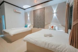 a bedroom with two beds with white sheets at Sleepdive Samaesan สลิพไดฟว แสมสาร in Sattahip