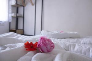 a pink flower sitting on top of a white bed at Deniz Apartments in Kappel-Grafenhausen