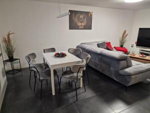 a living room with a couch and a table and chairs at Moers City Apartments in Moers