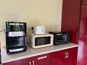 a kitchen with three microwaves on a counter at Orchard Villa, Radiant Janda Baik in Bentong