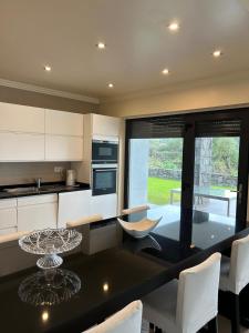 a kitchen with a black table and white cabinets at Deluxe House in Angra do Heroísmo