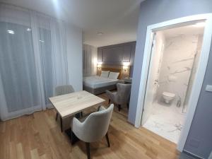 a room with a table and chairs and a bedroom at MN apartman in Banja Luka