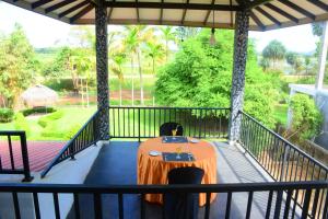 a table on a balcony with a view of a park at Green Lake View Yala Resort in Tissamaharama