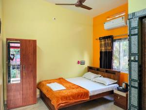 a bedroom with a bed with orange walls at Gokarna Thayi Krupa Homestay in Gokarn