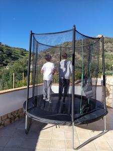 two people are standing on a trampoline at Casa La Fuente in El Chorro
