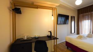 ローマにあるSuites 51の机とベッドのあるホテルの部屋
