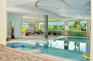 a house with a large swimming pool in a room at Hotel Rosa Resort in Cavareno