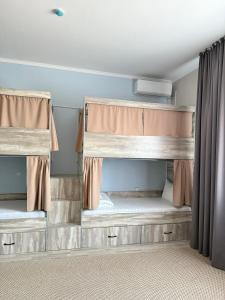 two bunk beds in a room with curtains at Shygys_hotel in Aktau +25 photos
