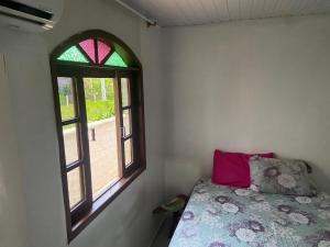una camera da letto con un letto e una finestra di Cantinho da Pinheira a Palhoça