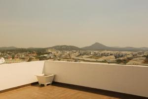 a white balcony with a view of a city at Trần Lê Hostel in Da Lat