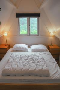 - un grand lit blanc dans une chambre avec deux lampes dans l'établissement Bosvilla Ardennen, à Durbuy