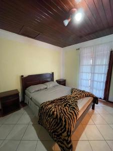 a bedroom with a zebra print bed in a room at Recanto da Araucária 2 in Campos do Jordão