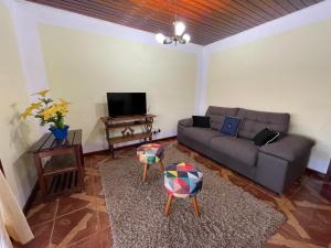 a living room with a couch and a tv at Recanto da Araucária 2 in Campos do Jordão +5 photos